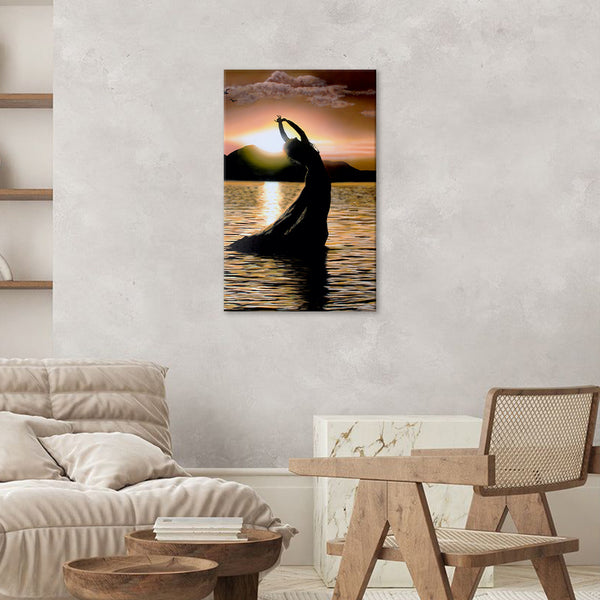 Silhouette of a person in a yoga pose against a sunset over water, hanging on a wall in a living room.