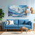 Living room with a blue sofa, mountain painting, and wooden coffee table.