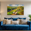 Blue sofa with decorative pillows in a room with a large painting of a pastoral scene on the wall.