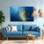 Blue sofa in a living room with a large abstract painting on the wall.