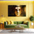 Living room with a green sofa, coffee table, and large wall art of a golden face.