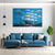 Modern living room with a blue sofa, coffee table, and decorative painting of a ship on the wall.