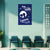 Blue poster with white design on a wall in a room with chairs and a plant.
