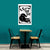 Table with two chairs against a teal wall with a framed black and white cat illustration.