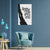 Modern living room with a blue armchair, side table, and abstract wall art on a blue wall.