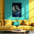 Yellow sofa with decorative pillows against a teal wall with a moon and star painting.