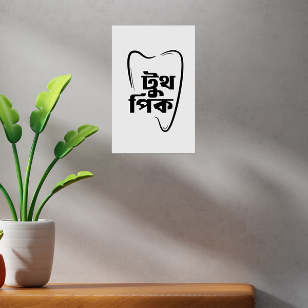 White wall with a tooth-shaped poster featuring black text, next to a potted plant on a wooden surface.