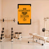 Motivational poster on a wall in a gym with exercise equipment.