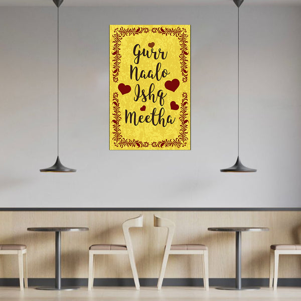 Decorative wall art with text and hearts on a yellow background in a modern cafe setting.