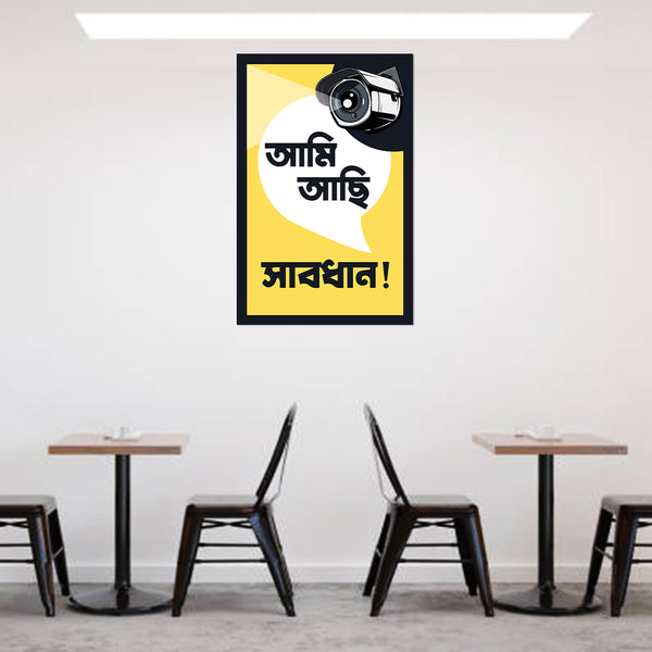 Framed poster with text and a camera graphic on a wall above a cafe setup.