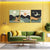 Modern living room with a green sofa, yellow walls, and abstract wall art.