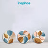 Three circular coasters with leaf patterns on a light gray background, featuring the brand 'inephos'.