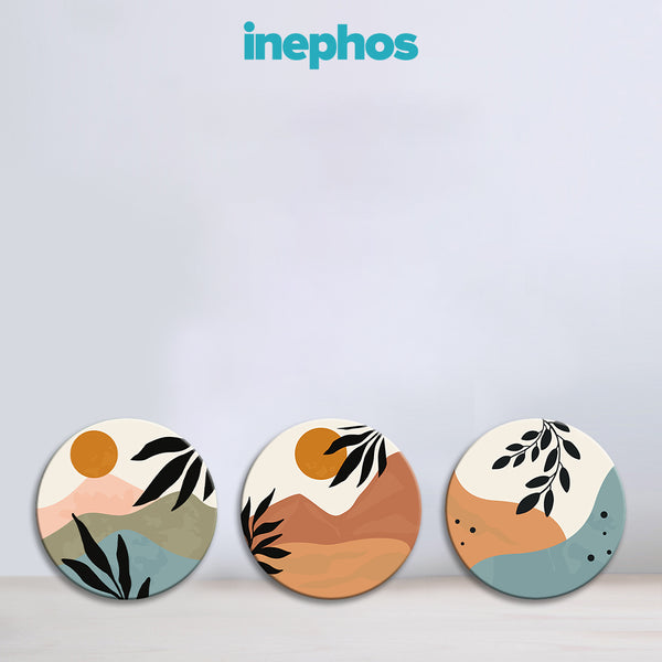 Three circular coasters with artistic designs on a light gray background, featuring the brand 'inephos'.
