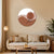 Living room with a beige sofa, decorative pillows, a round coffee table, and a wall art piece.