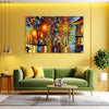 Living room with a green sofa, coffee table, and colorful painting on a yellow wall.