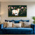 Blue sofa with decorative pillows and a colorful painting of a cow and calf on the wall.