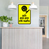 Yellow and black sign on a wall above a counter with plants and lights.
