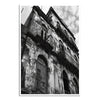 Black and white photograph of an old, weathered building with balconies against a cloudy sky.