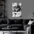 Black and white portrait of a revered figure on a wall above a dark gray sofa in a living room.