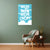 Wall with a blue poster with white text on a green wall, brown chair with a green blanket, and small wooden table with a plant.