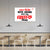 Modern interior with a white wall featuring a red and black sign.