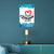 Decorative wall poster with colorful text and design on a blue wall above a teal sofa.