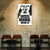 Motivational poster with text on a wall in a room with wooden chairs and tables.
