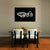 Dining area with a table and chairs, and a black wall art piece with white text on a gray wall.