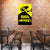 CCTV camera sign on a brick wall with tables and chairs below